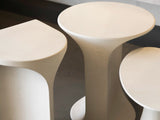 A close up of three concrete side tables.