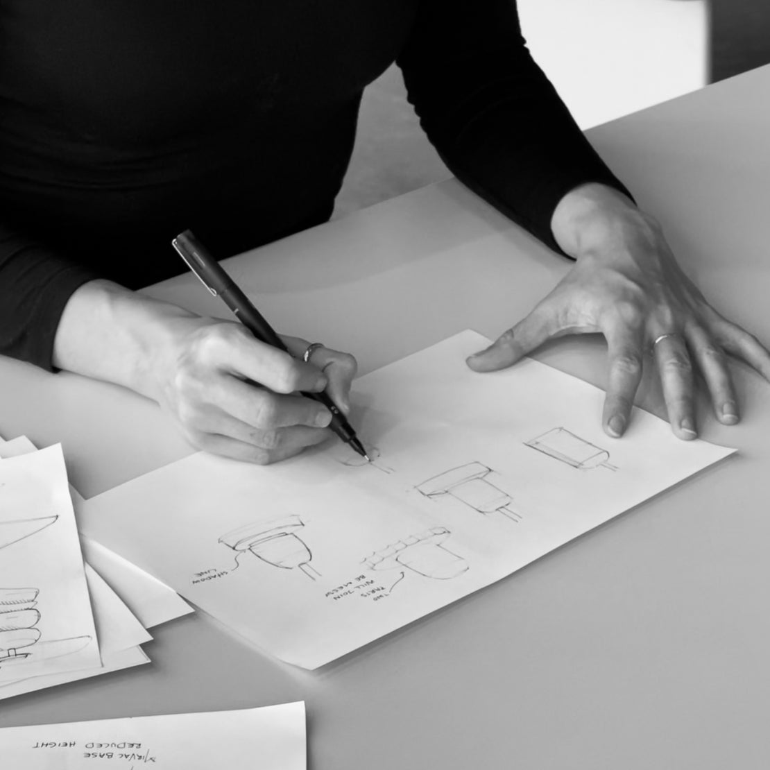 Industrial Designer sketching product design concepts by hand on paper.