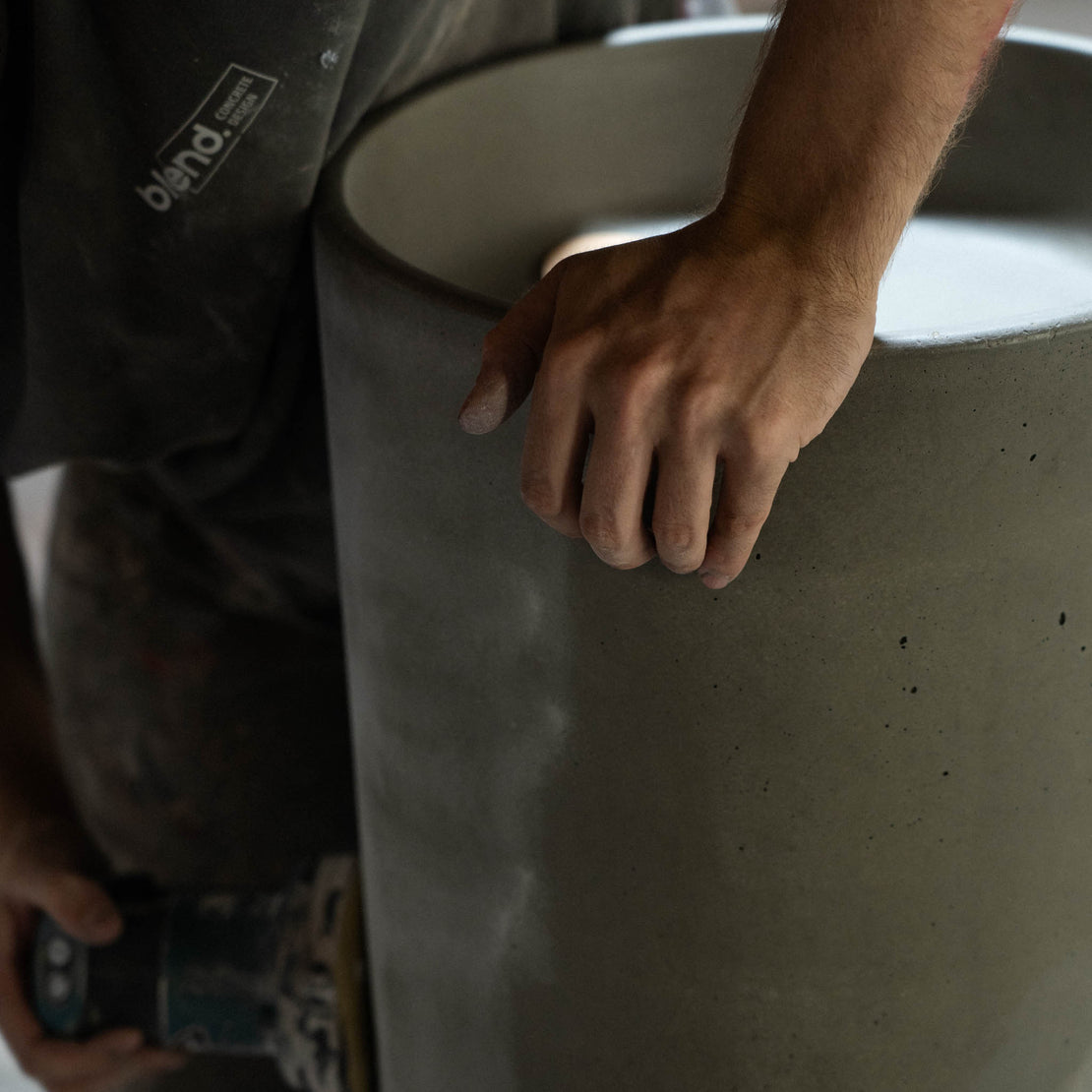 A concrete maker sanding the Athena Concrete Pedestal Basin.