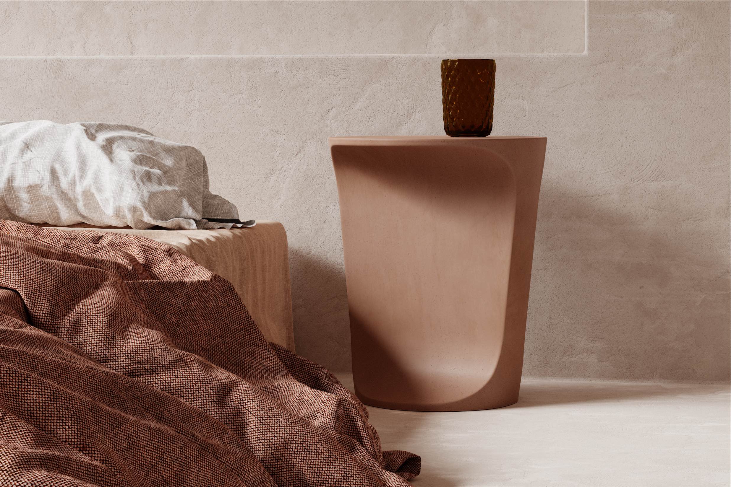 An Alpine Concrete Side Table sitting next to a bed setting.