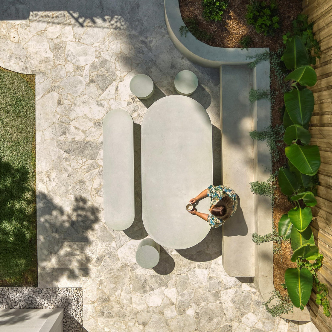 A birds eye image of an outdoor rea featuring the Verona Concrete Dining Table, a custom concrete bench seat and three Dune Concrete Side Tables.