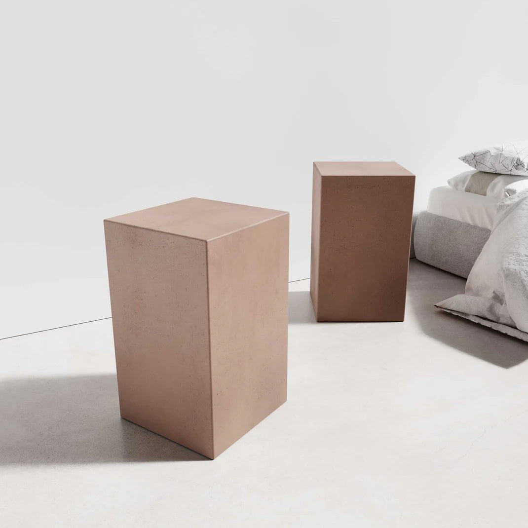 Two Sahara Concrete Side Tables in the concrete colour Dingo, featuring smooth, square bases and have rectangular shapes.