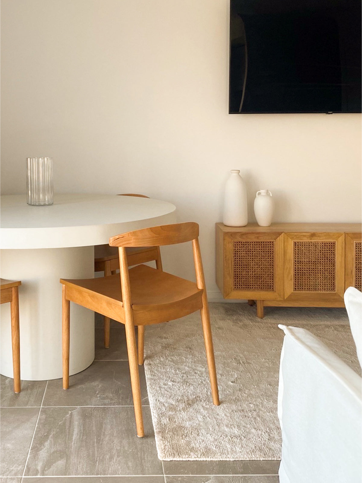 A Small Tuscan Concrete Dining Table in Whitehaven in a living room with wooden chairs around the table