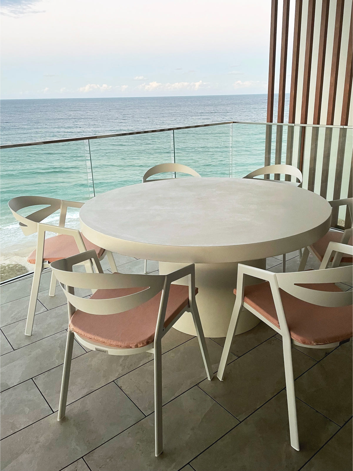 A Medium Tuscan Concrete Dining Table on a balcony overlooking the ocean