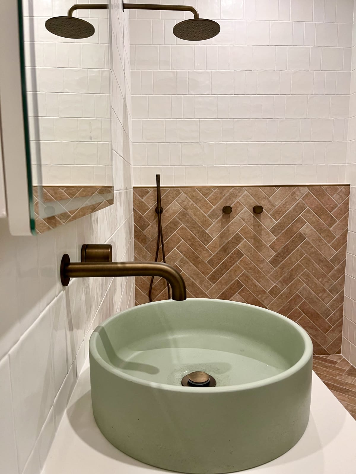 Comet Concrete Basin in Rainforest  Green with antique brass tapware and light brown tiling featured behind