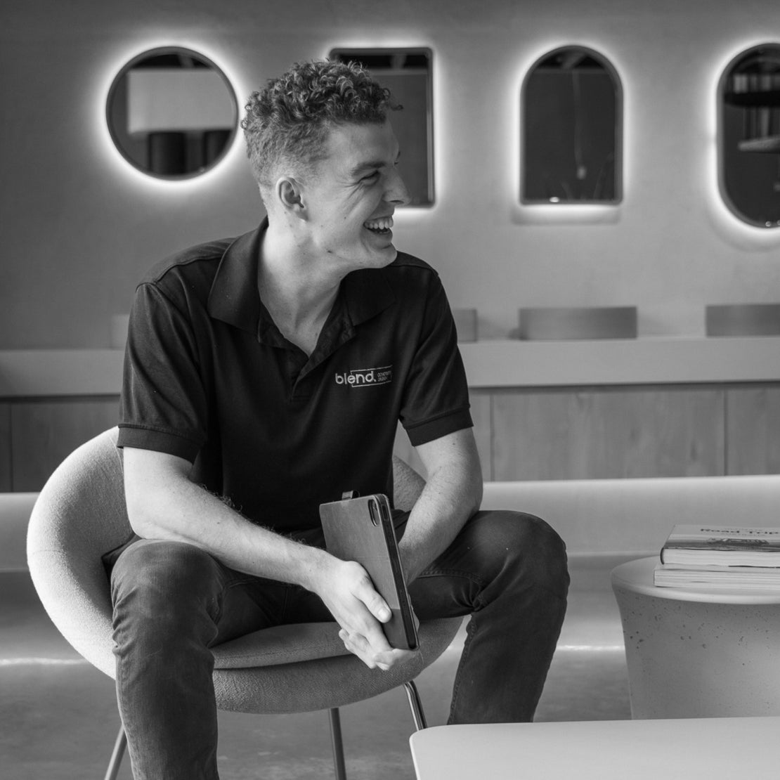 Sales person sits on chair in showroom with concrete pieces surrounding them