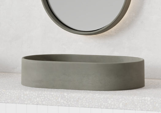An Eclipse Concrete Basin in the colour Granite Grey on a terrazzo concrete vanity top with a matching Lunar Concrete Mirror with LED backlighting.