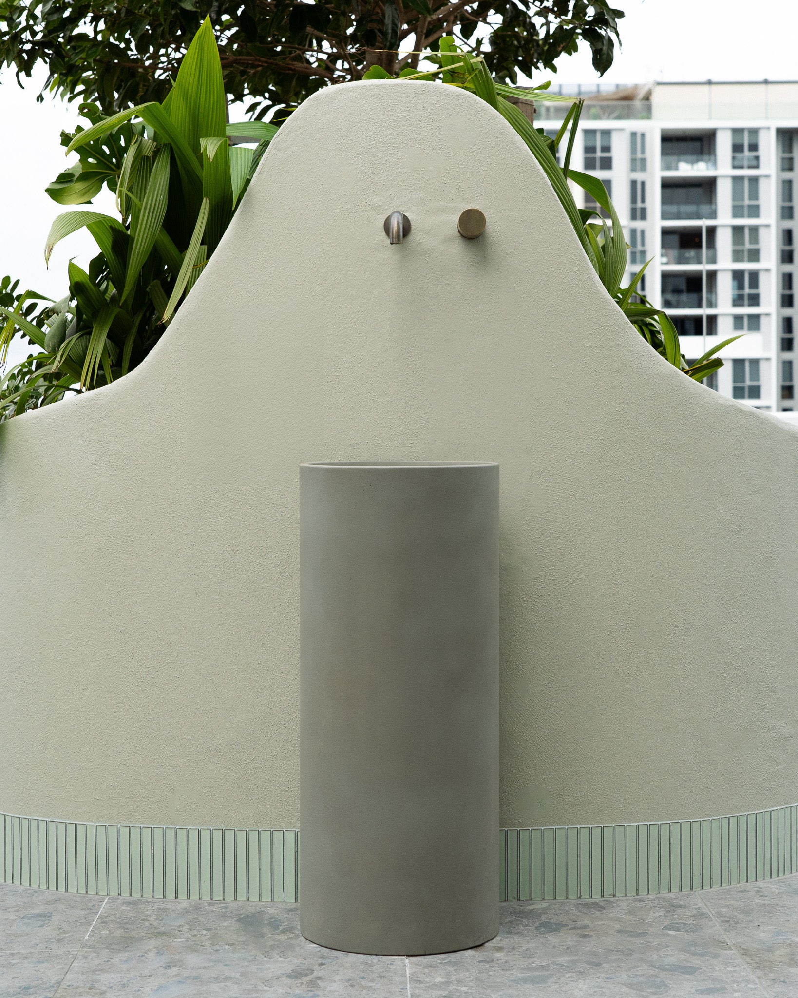 The Athena Concrete Pedestal Basin sits outside on a rooftop.