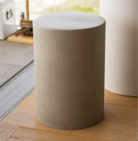 A Dune Concrete Side Table on the veranda of a coastal apartment. 