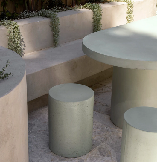 Two Dune Concrete Side Tables being used as stools in a renovated outdoor patio with  a Verona Concrete Dining Table.