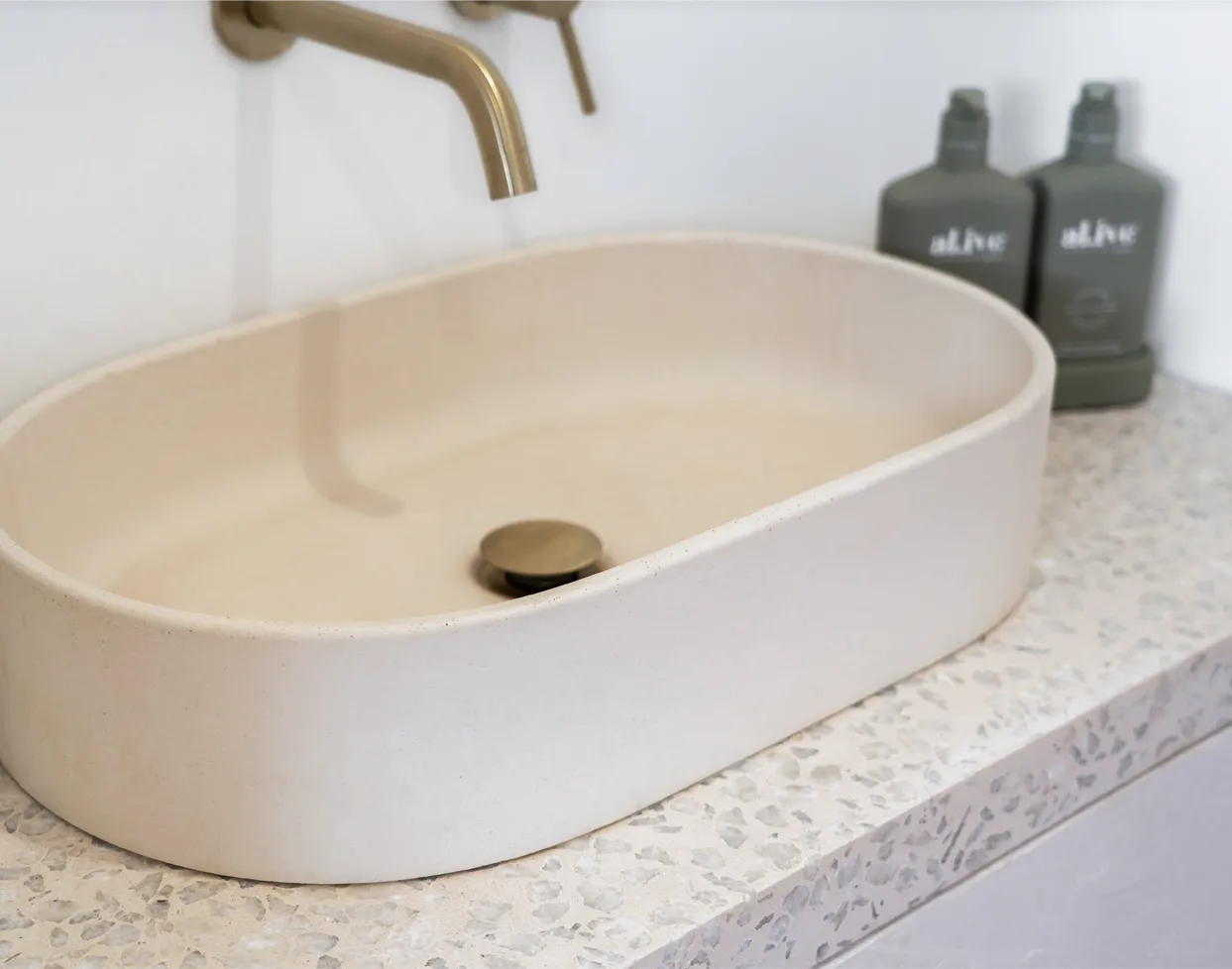 An Eclipse Concrete Basin in the colour sand on a custom concrete terrazzo vanity top created by Blend Concrete Design.