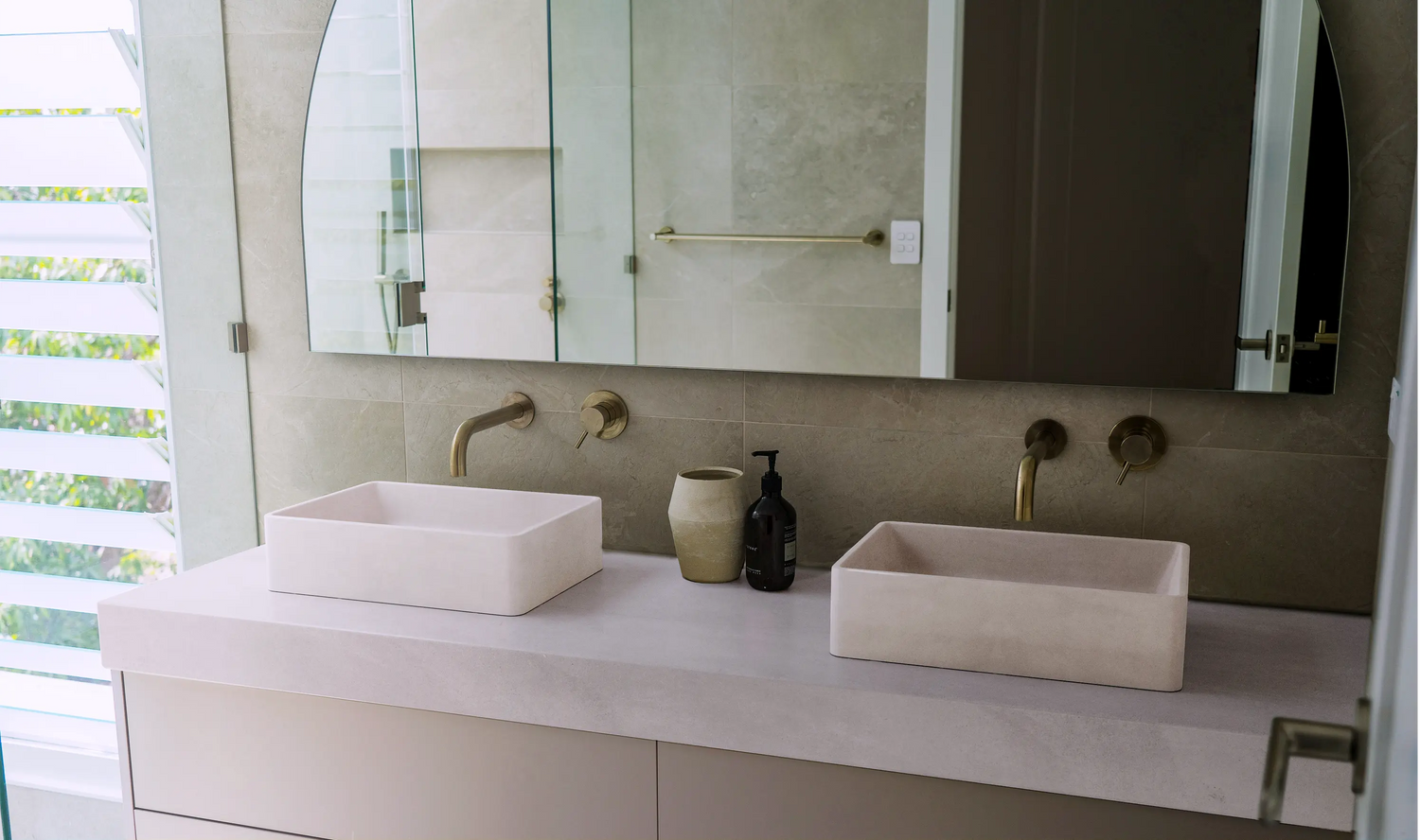 A well light bathroom with his and hers matching Nova Concrete Basins in the colour whitehaven. 