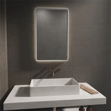 A stellar concrete led mirror and matching Horizon Concrete Basin in a grey bathroom and a concrete vanity unit.