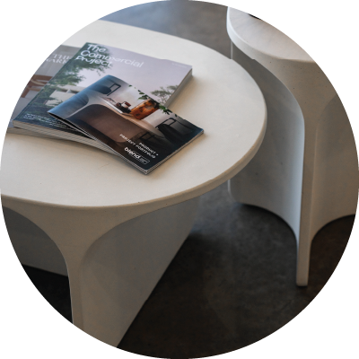A white Riviera Concrete Coffee Table and a white Isle Concrete Side Table. 