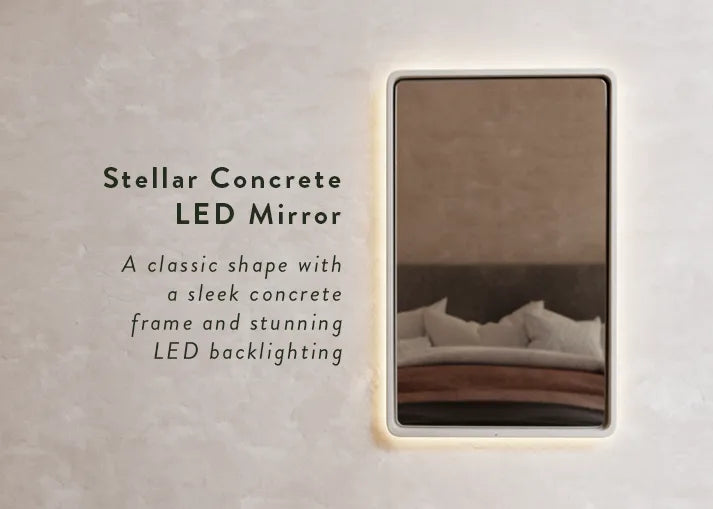 A stellar Concrete Mirror on a cream microcement rendered wall with the text "Stellar Concrete LED mirror - a classic shape with a sleek concrete frame and stunning LED backlighting".