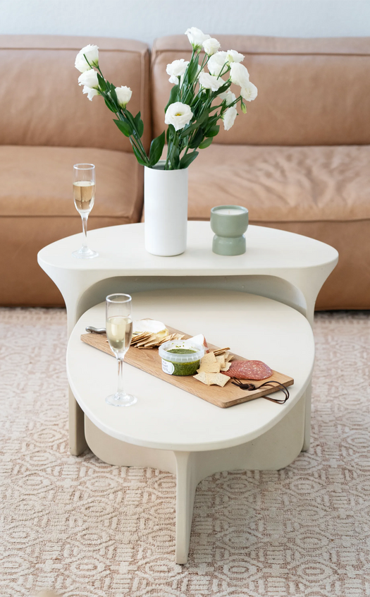 The Riviera Concrete Nesting Set in a modern living room decorated with flowers and a cheese board.