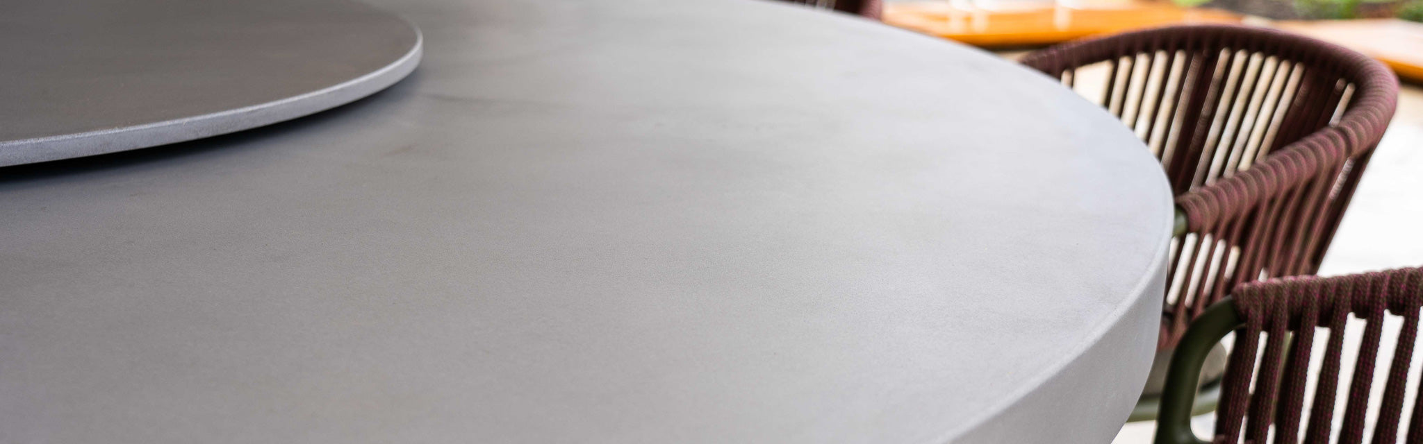 Image of a concrete dining table with a lazy susan in the middle.