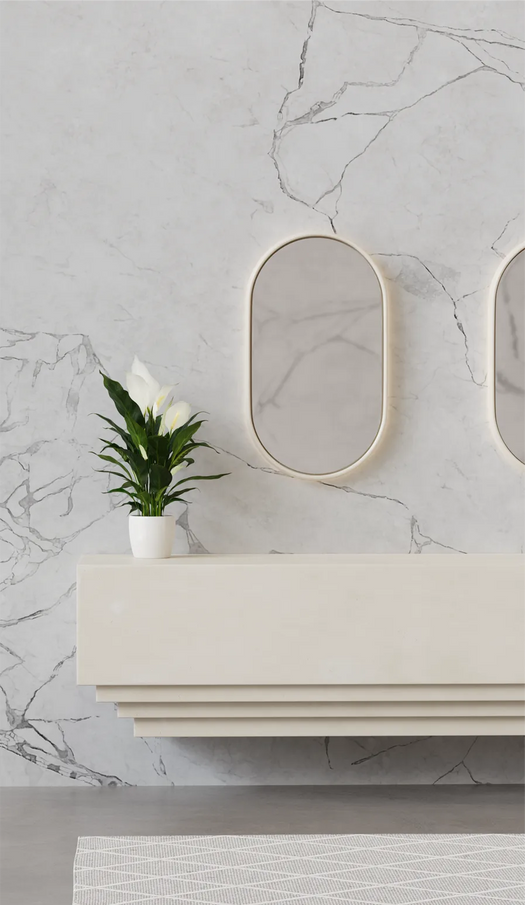 A white Lunar Concrete LED Mirror in the colour whitehaven on a marble wall and white console unit in an entryway of a hotel.