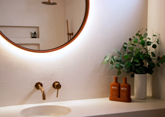 A Large round Sol Concrete LED Mirror with a concrete vanity top with an integrated bathroom sink. 