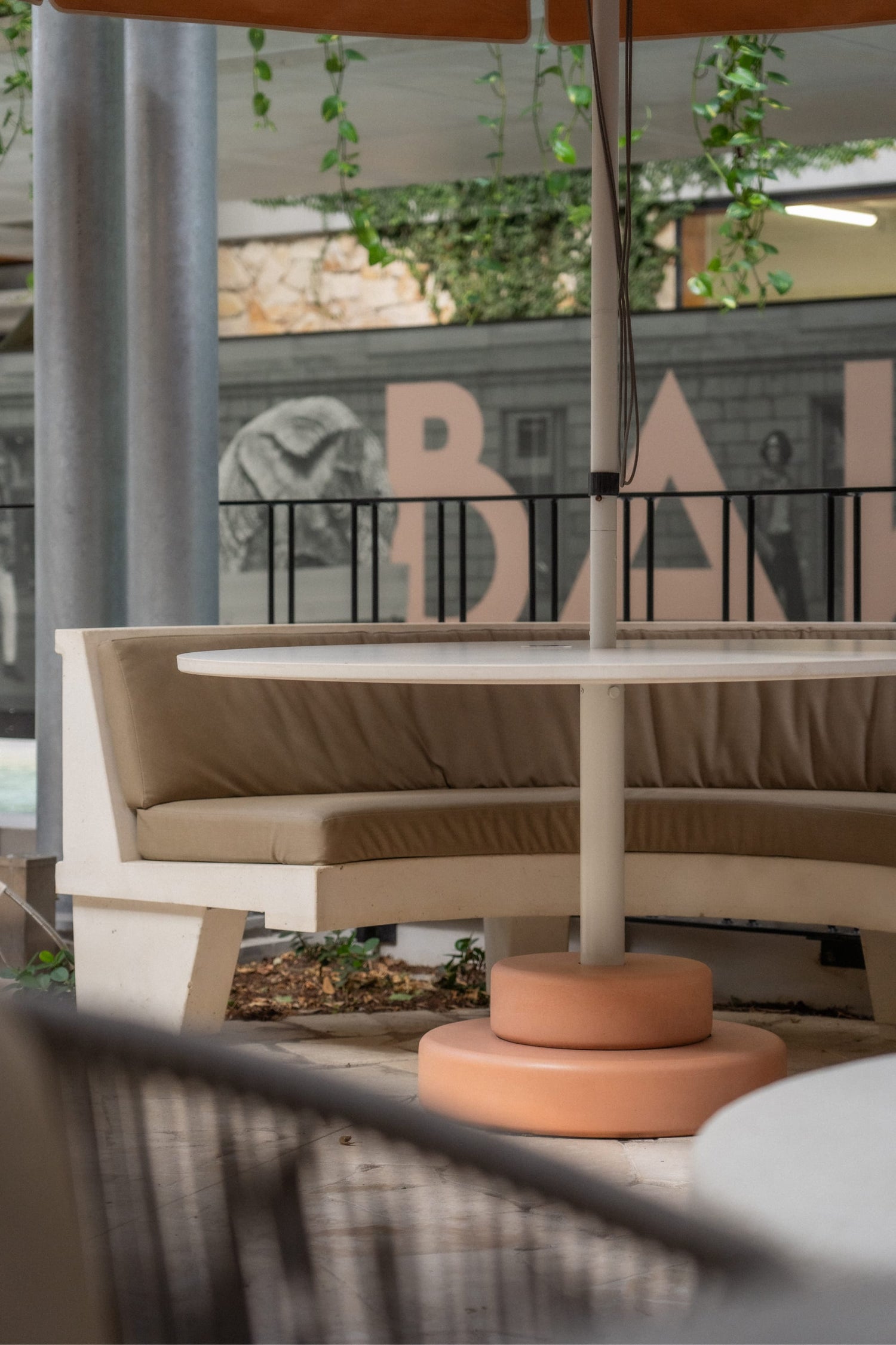 Wide angled image of the courtyard dining space at Total Fusion Platinum. The outdoor area features custom concrete dining tables.